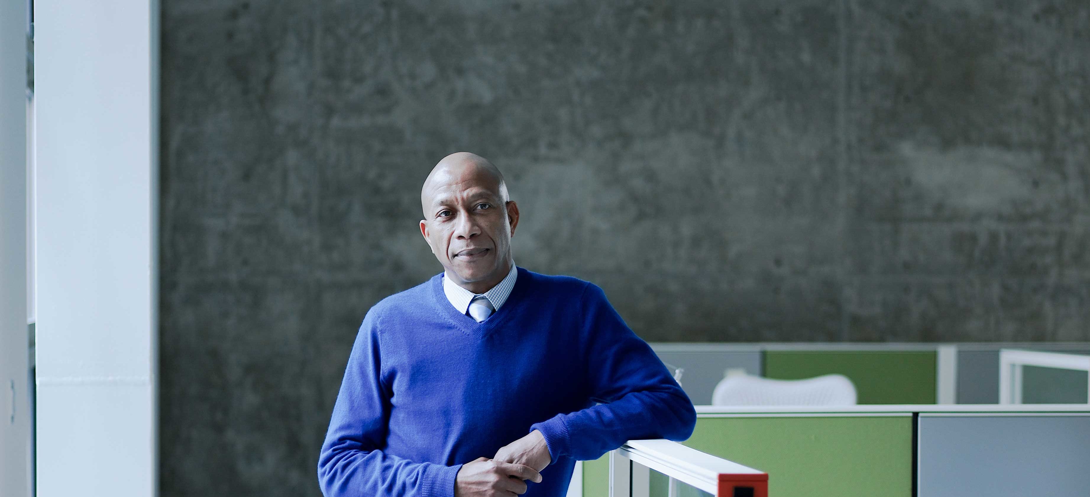 Businessman Leaning On Workstation