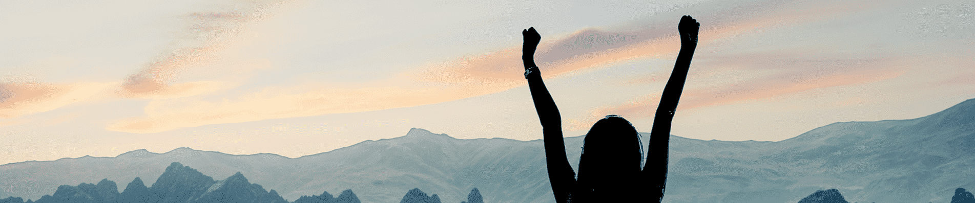 silhouette of business woman celebrating on top of a mountain